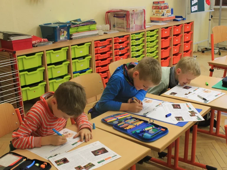 Kinder füllen ein Aufgabenblatt zur Umwelt aus