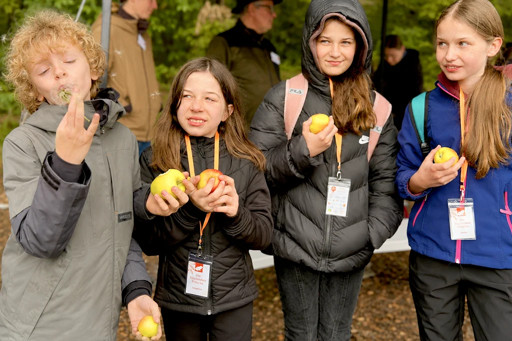 Die Kinder lernen: Dank den Wildbienen können sie leckeres Obst, wie Äpfel genießen.